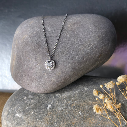 Silver necklace with a pendant on a stone surface
